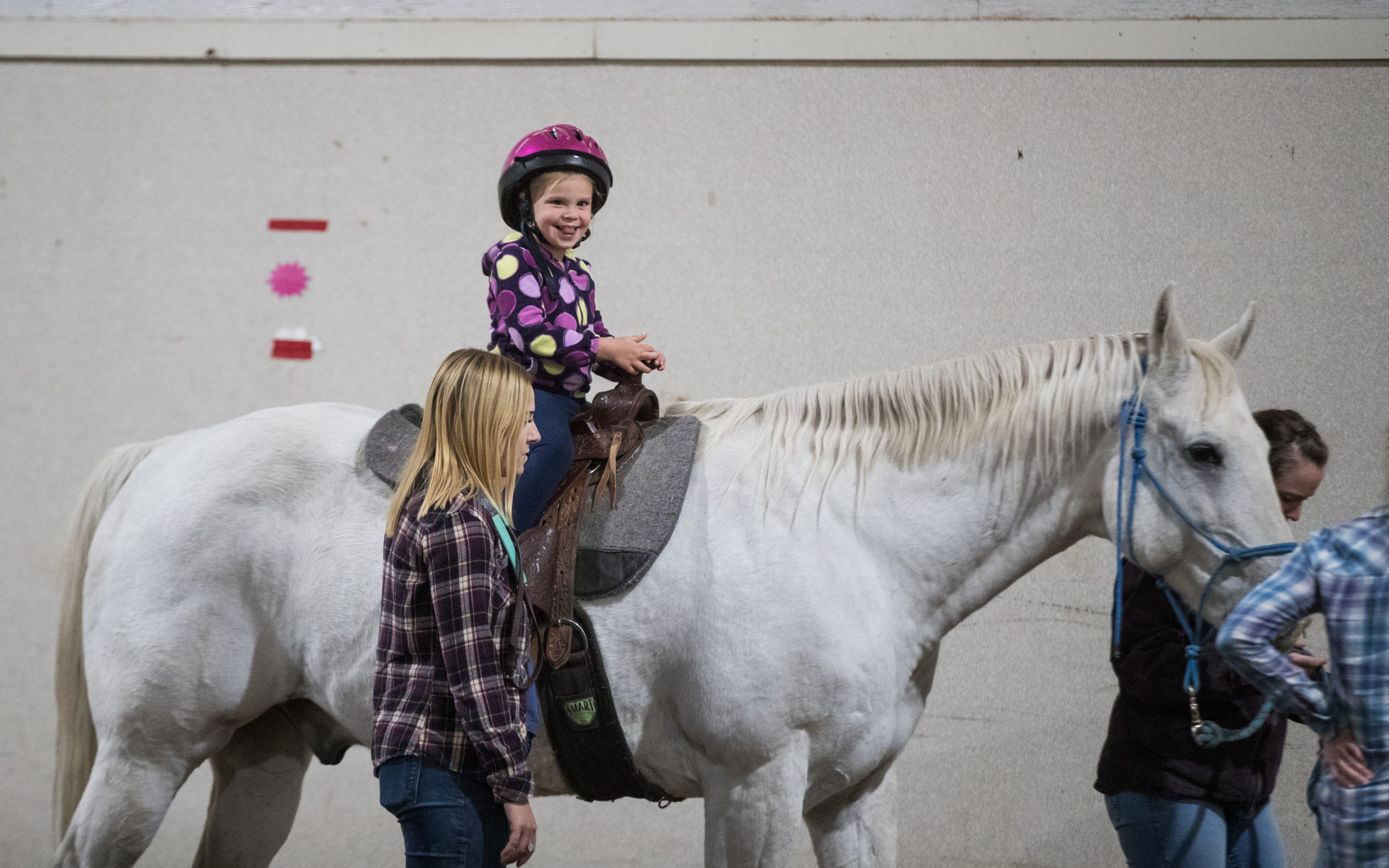 Hazel Guerette giggles at her mother across the arena as she begins her lesson on Jack, a big gray horse that was donated to Trotting Horse Therapeutic Riding, after competing in high-level roping competitions. Jack has learned to take it slow these days, helping various patients improve skills and strengths through hippotherapy and equine-assisted activities that are provided at Trotting Horse Therapeutic Riding.