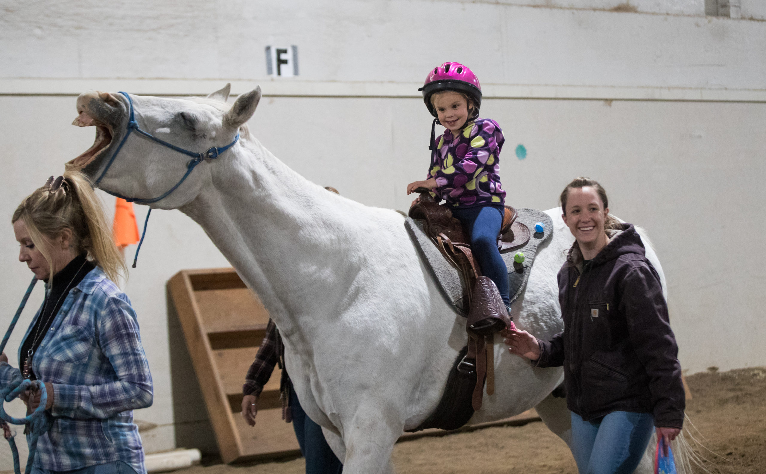 Staff physical therapist, Sam Morton, walks along Hazel Guerette during her session.