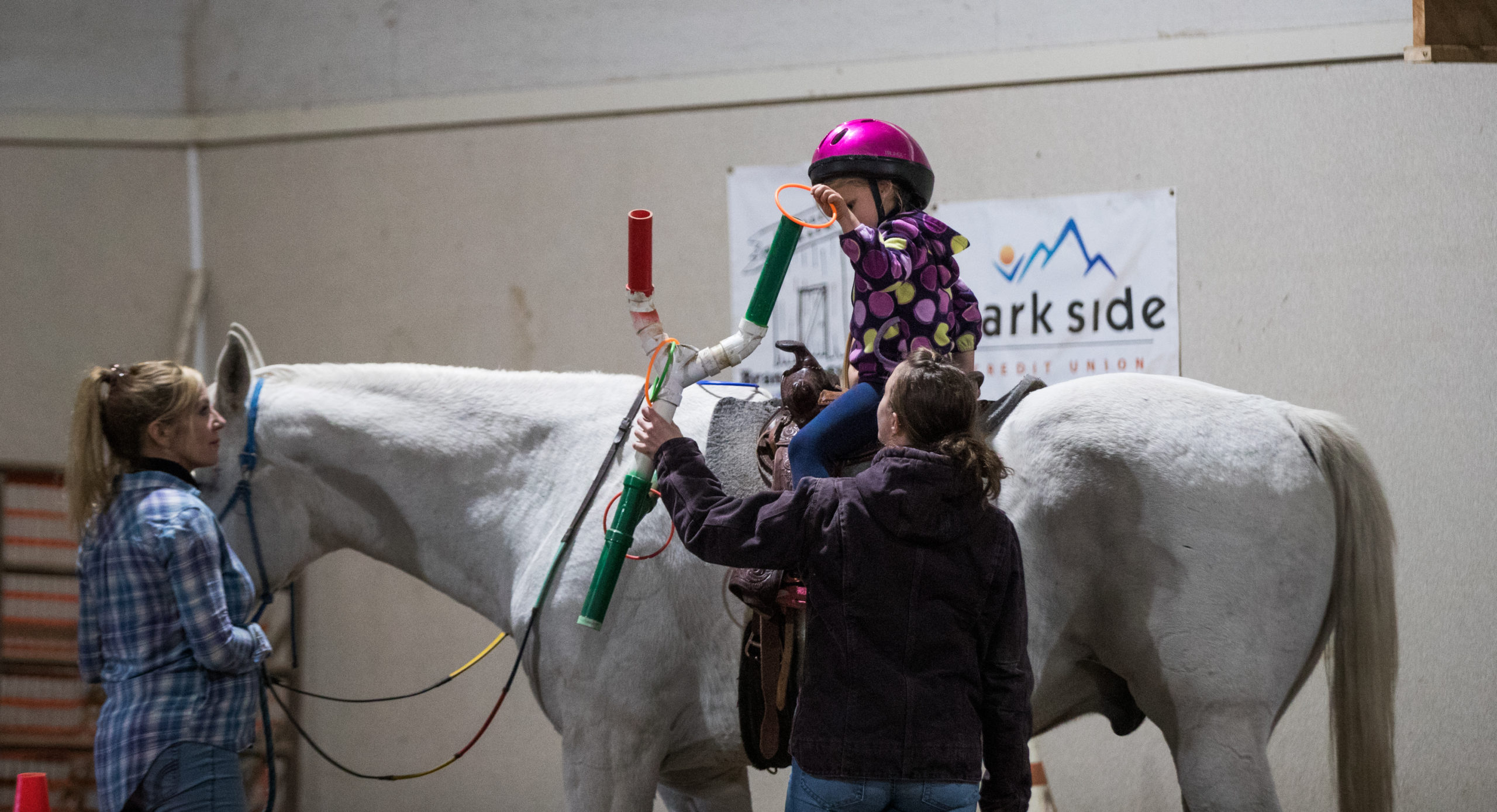 Hazel Guerette puts an orange hoop on a pipe “tree” during her lesson. The tree will be moved all around Jack’s body and Guerette will follow it around, putting colorful hoops on and having fun while simultaneously getting stronger.