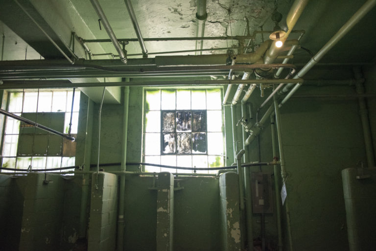 Pipes and plumbing run along the ceiling in the showers at the old Montana State Prison.